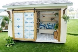 Shed exterior with sliding door open to reveal interior sitting room.