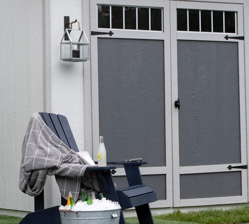 Pool shed: Image of double doors. Poolside chair with drink ice bucket.