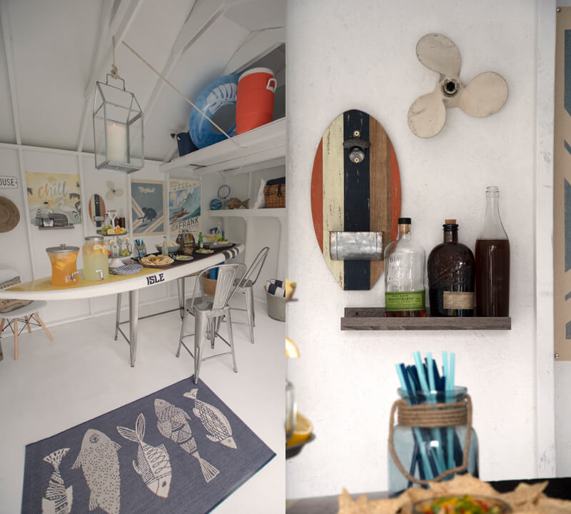 Pool shed interior. Table shaped like a surf board with food on top. Tropical themed wall decor.